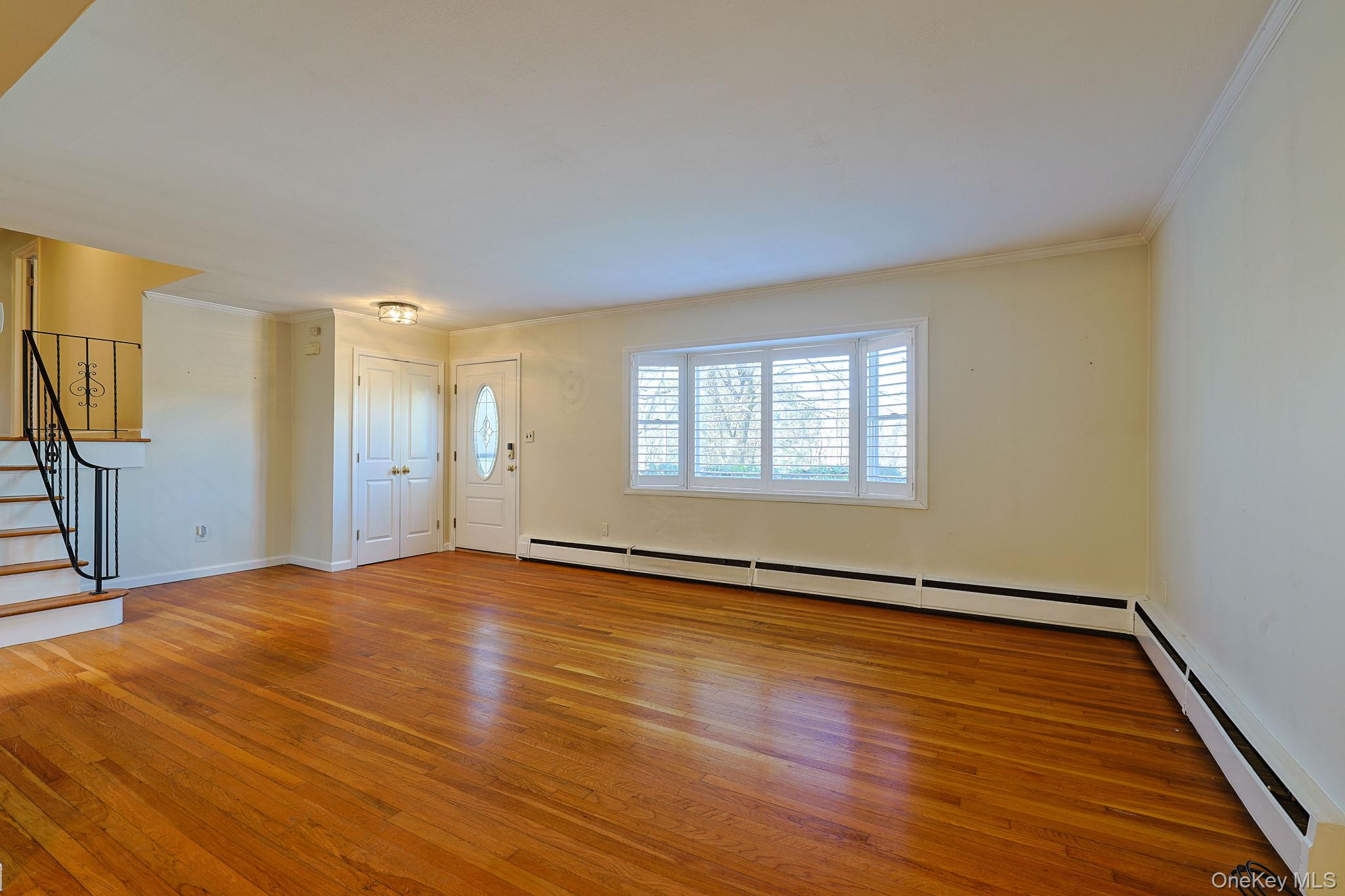210 Varian Road Cortlandt Manor, NY 10567 - Photo 9 of 29 a view of an empty room with wooden floor and a window