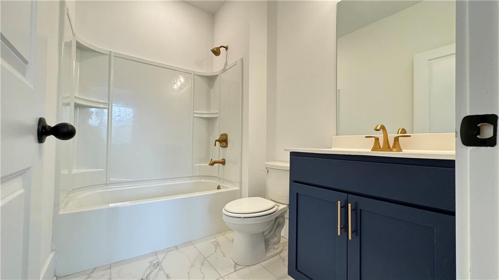 1585 Layton Lane Northwest Atlanta, GA 30318 - Photo 5 of 61 a bathroom with a sink a toilet and a large mirror