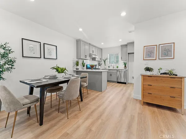 a kitchen with stainless steel appliances kitchen island granite countertop a table chairs and wooden cabinets