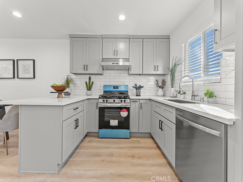 1056 Walter Avenue Tustin, CA 92780 - Photo 24 of 39 a kitchen with stainless steel appliances granite countertop a sink stove and refrigerator