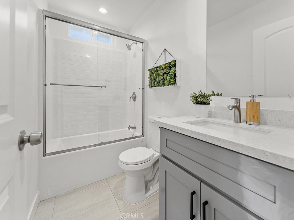 1056 Walter Avenue Tustin, CA 92780 - Photo 33 of 39 a bathroom with a granite countertop sink toilet and shower