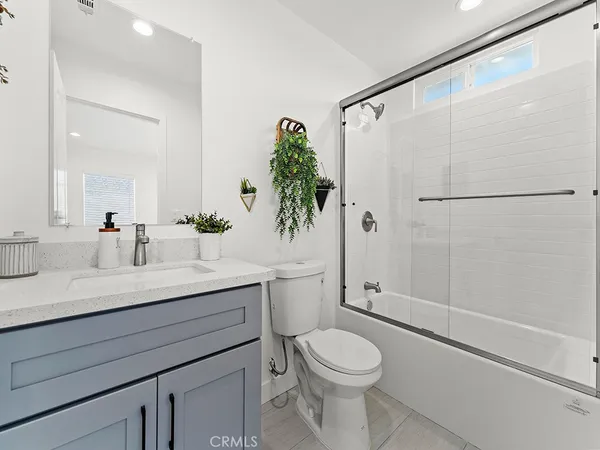a bathroom with a granite countertop sink a toilet and shower