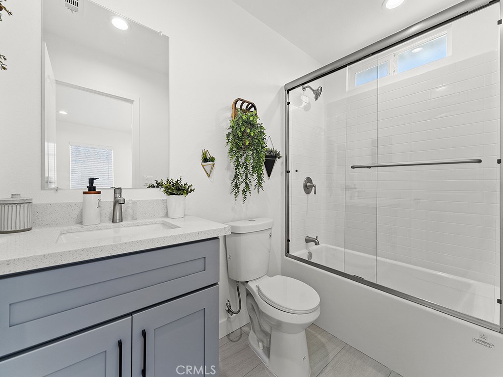 1056 Walter Avenue Tustin, CA 92780 - Photo 34 of 39 a bathroom with a granite countertop sink a toilet and shower