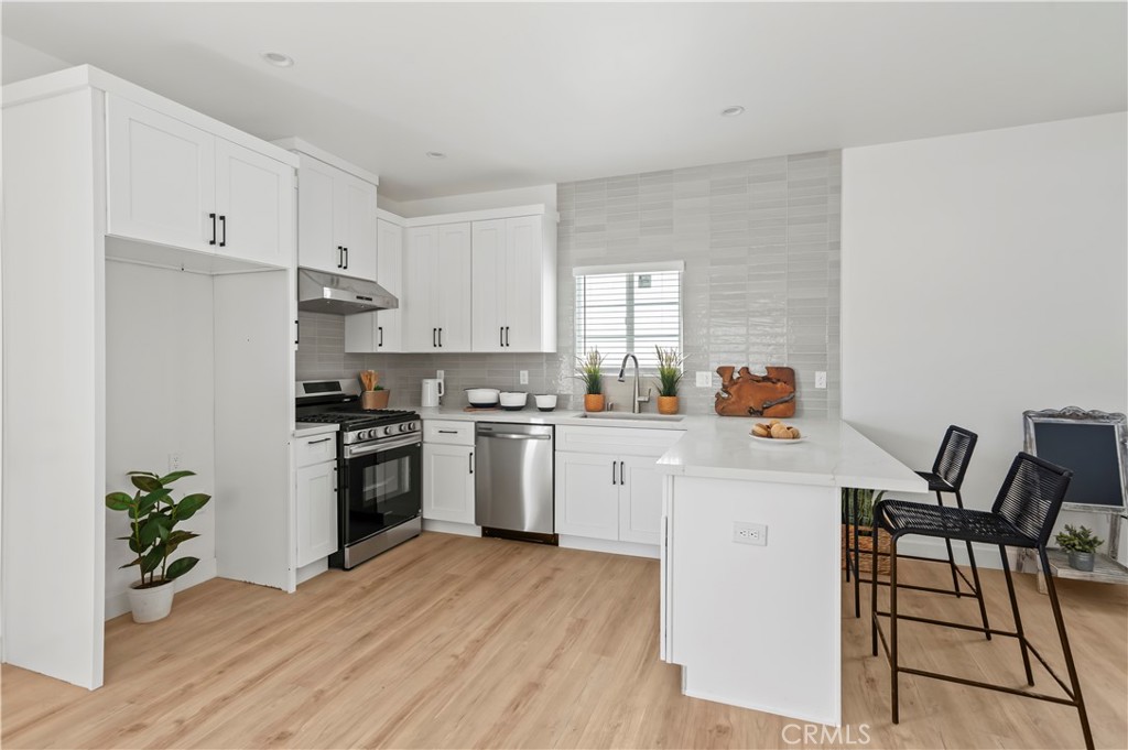 1056 Walter Avenue Tustin, CA 92780 - Photo 4 of 39 a kitchen with granite countertop white cabinets and stainless steel appliances