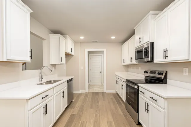 a kitchen with a sink stove top oven and cabinets