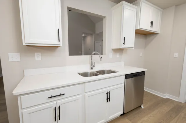 a kitchen with white cabinets and a sink