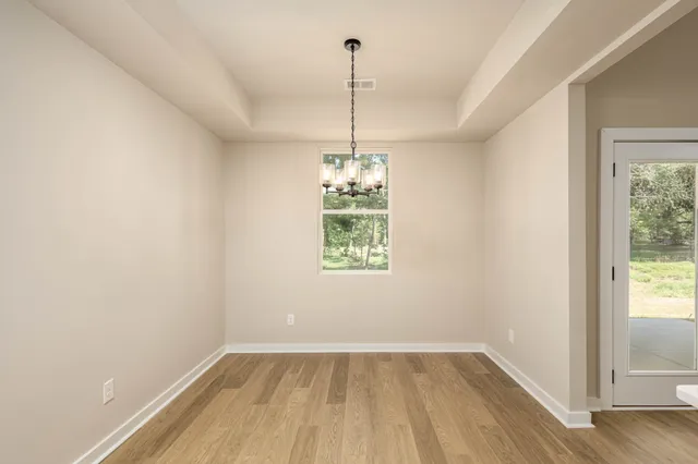 a view of a room with window wooden floor and front door