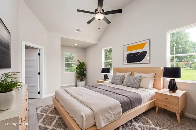 a bedroom with a bed a couch and potted plant