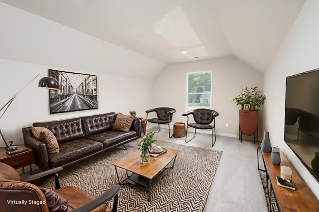 a living room with furniture a rug and a flat screen tv