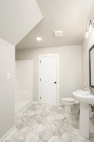 a bathroom with a sink toilet and shower