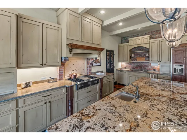 a kitchen with kitchen island granite countertop a sink cabinets and stainless steel appliances