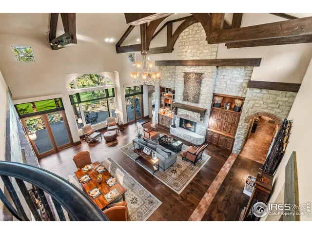 a spacious bedroom with a bed a table and a chandelier