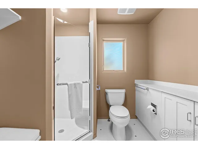 a spacious bedroom with a bed a table and a chandelier