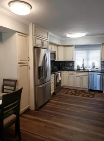 a kitchen with granite countertop a refrigerator and cabinets