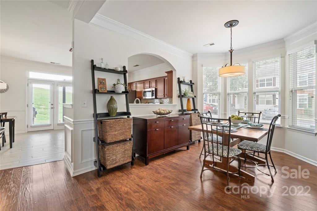 7383 Laurel Valley Road Charlotte, NC 28273 - Photo 12 of 37 a kitchen with stainless steel appliances a dining table chairs and wooden floor