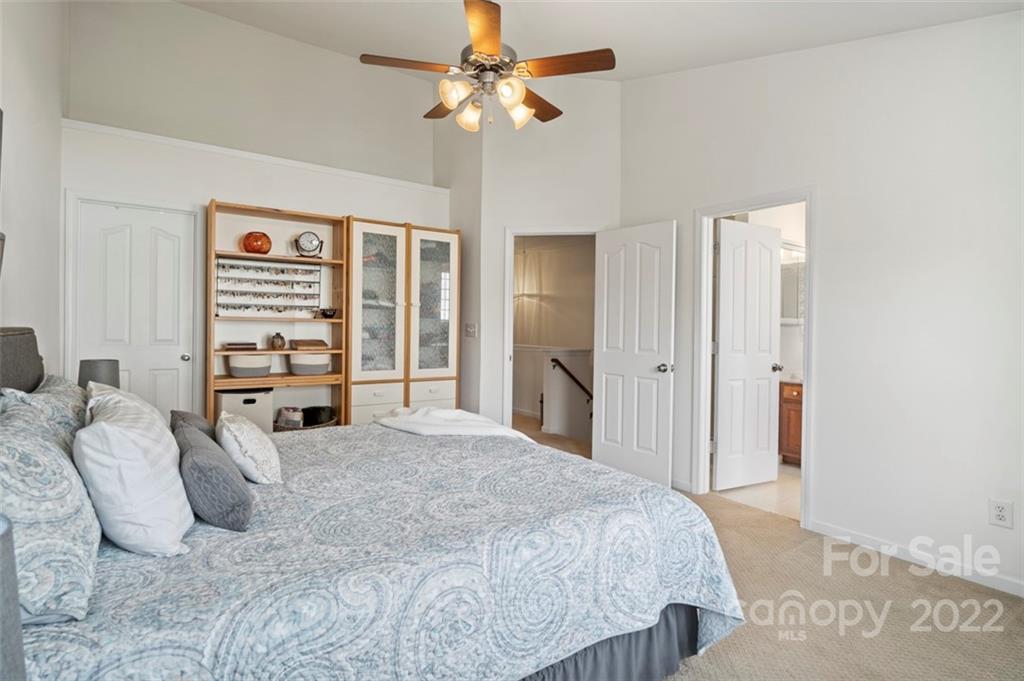 7383 Laurel Valley Road Charlotte, NC 28273 - Photo 23 of 37 a bedroom with a large bed and a chandelier