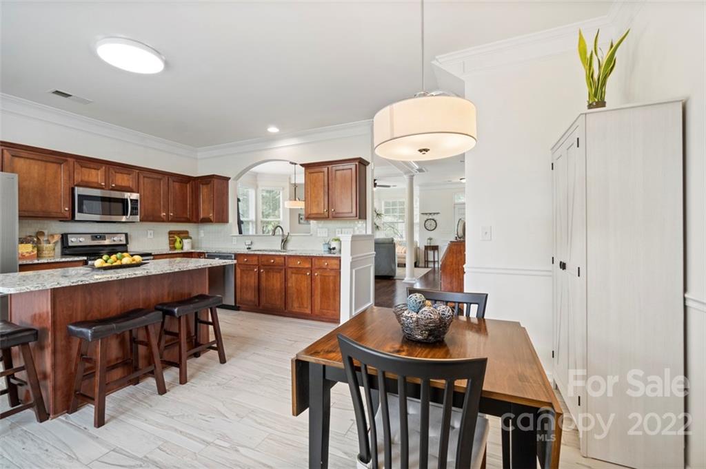 7383 Laurel Valley Road Charlotte, NC 28273 - Photo 10 of 37 a kitchen with stainless steel appliances granite countertop a stove refrigerator and a view of living room
