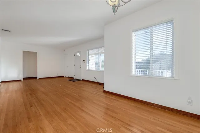 a view of empty room with wooden floor