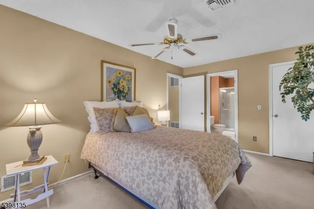 a bedroom with a bed and lamp on desk