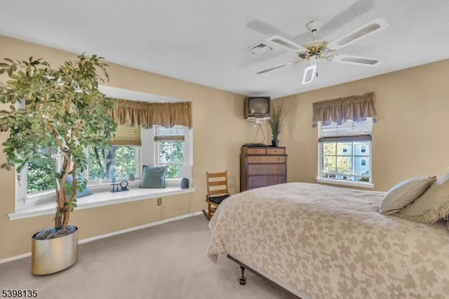 a bedroom with a large bed and windows