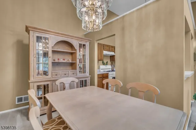 a bedroom with a bed a chandelier and dresser