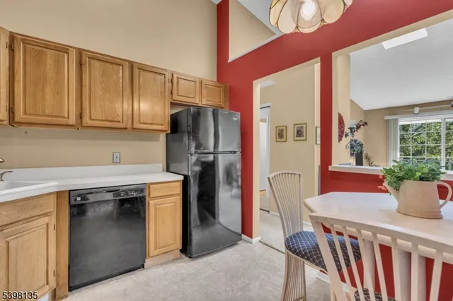 a kitchen with stainless steel appliances granite countertop a refrigerator a stove a sink cabinets and a dining table