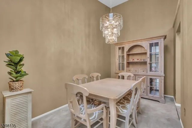 a view of a dining room with furniture a chandelier and wooden floor