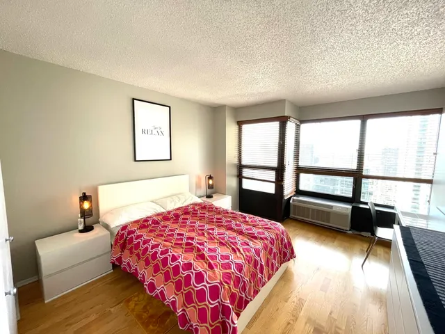 a bedroom with a bed and a large window