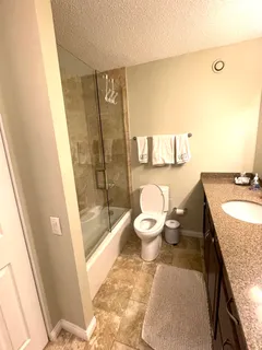 a bathroom with a granite countertop sink toilet and shower
