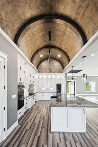 a kitchen with stainless steel appliances kitchen island granite countertop a sink and cabinets