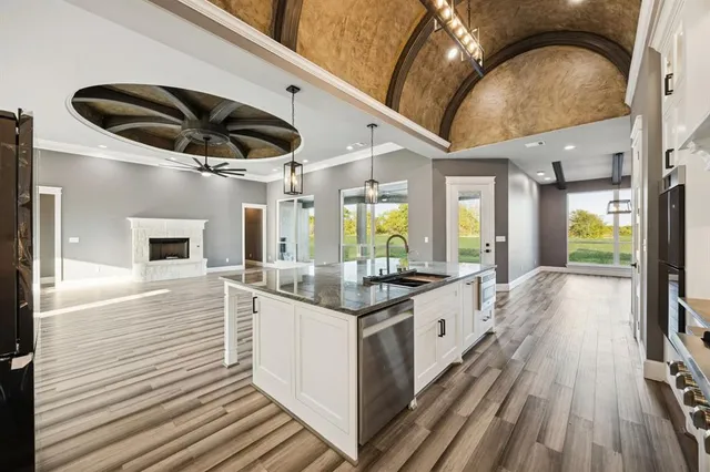 a view of a room with wooden floor and a ceiling fan