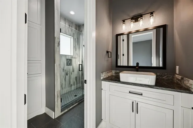 a bathroom with a granite countertop sink and a mirror