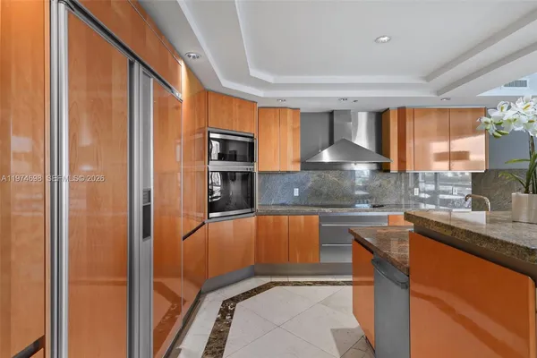 a kitchen with stainless steel appliances granite countertop a refrigerator and a sink