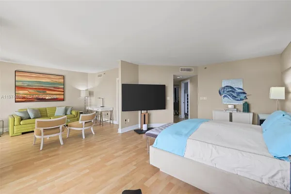 a living room with furniture a wooden floor and a flat screen tv