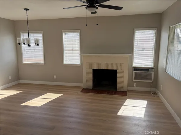 a view of empty room with wooden floor and fireplace
