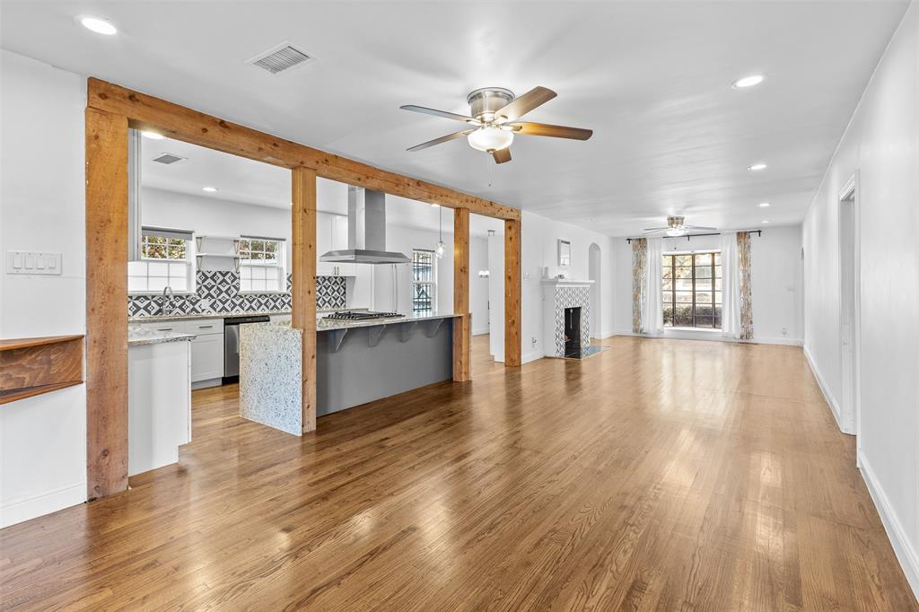 1902 Norfolk Avenue Dallas, TX 75203 - Photo 19 of 40 a view of an empty room and kitchen with wooden floor and a kitchen