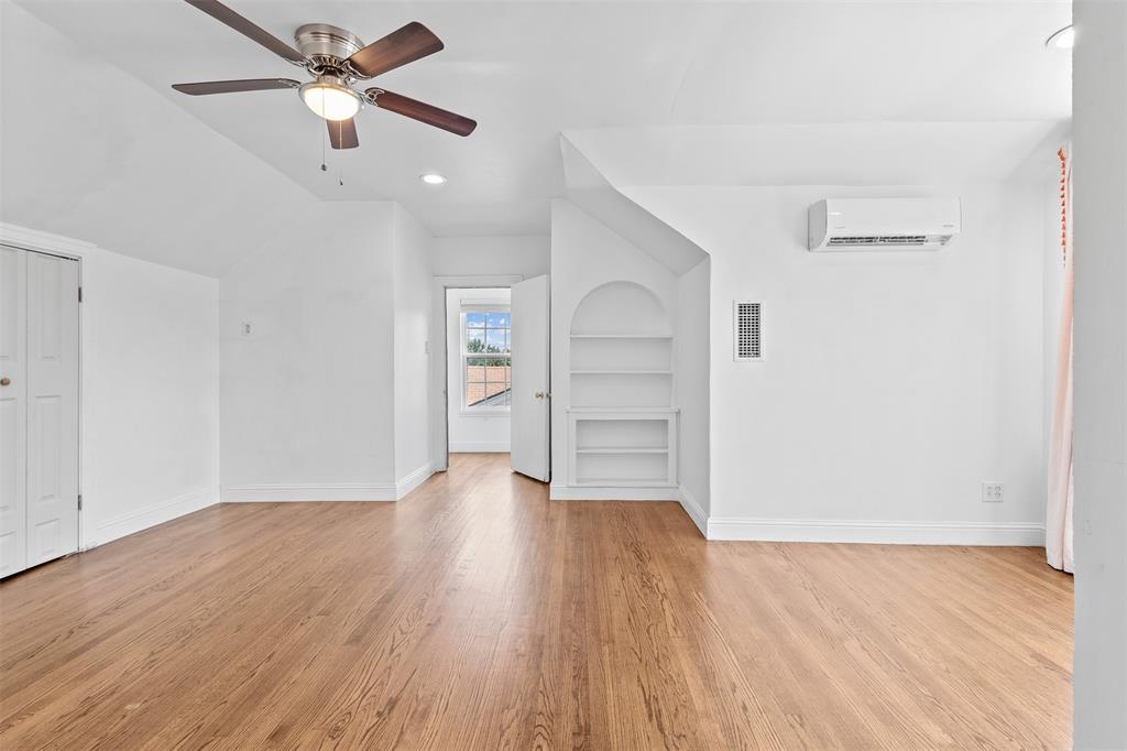 1902 Norfolk Avenue Dallas, TX 75203 - Photo 6 of 40 an empty room with wooden floor chandelier fan and windows