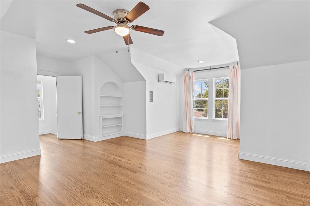 1902 Norfolk Avenue Dallas, TX 75203 - Photo 8 of 40 a view of an empty room with wooden floor and a ceiling fan