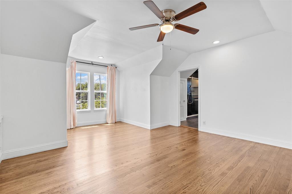 1902 Norfolk Avenue Dallas, TX 75203 - Photo 9 of 40 an empty room with wooden floor ceiling fan and windows