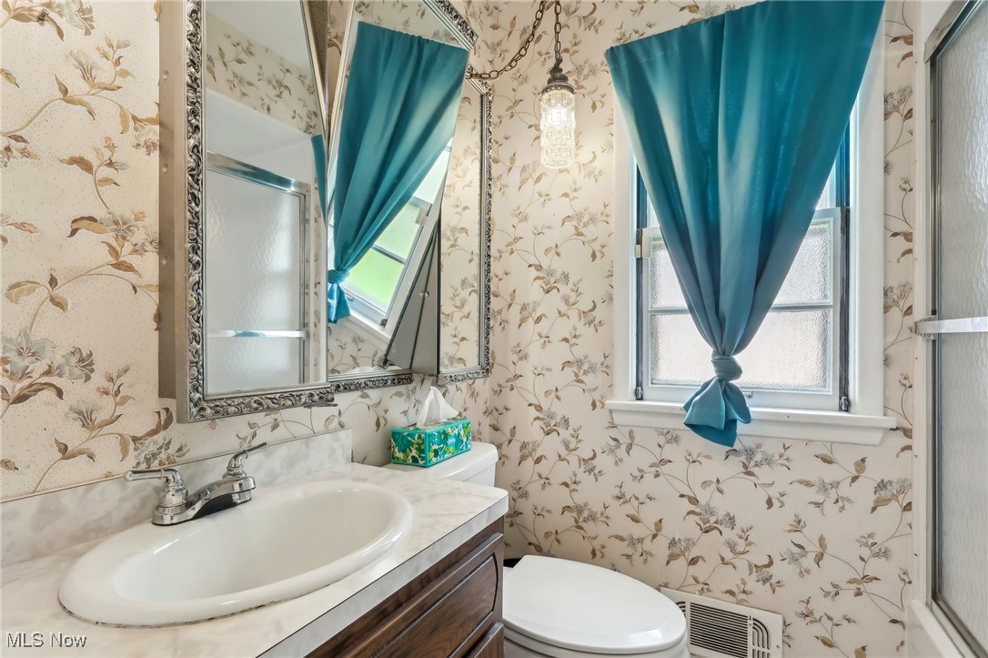 13676 Whitney Road Strongsville, OH 44136 - Photo 28 of 46 Bathroom with wallpapered walls, a stall shower, toilet, and vanity