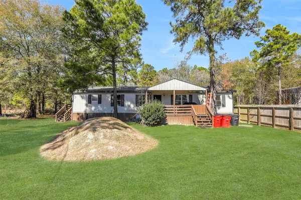 a view of a house with backyard and a tree