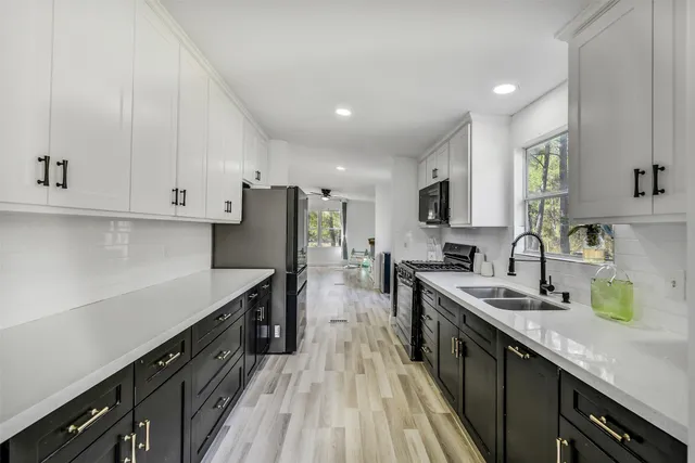 a kitchen with stainless steel appliances sink stove microwave and cabinets