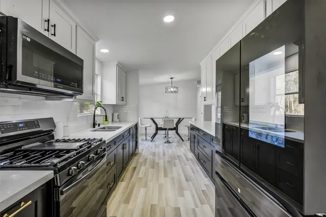 a kitchen with a stove a sink and a microwave