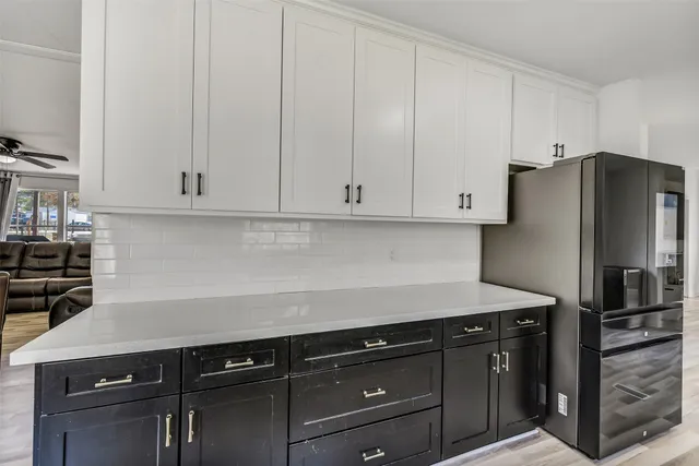 a kitchen with granite countertop white cabinets and stainless steel appliances