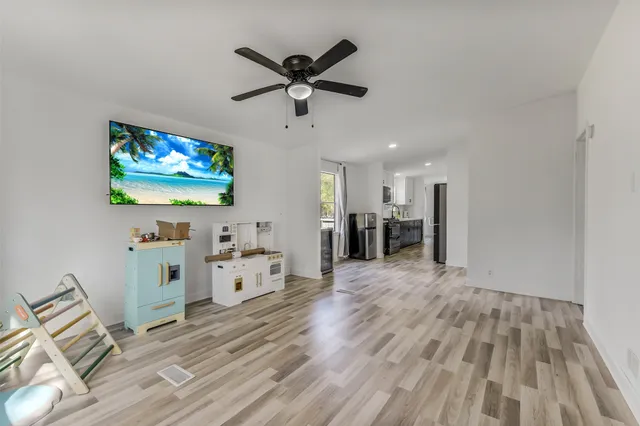 a view of an empty room and a kitchen