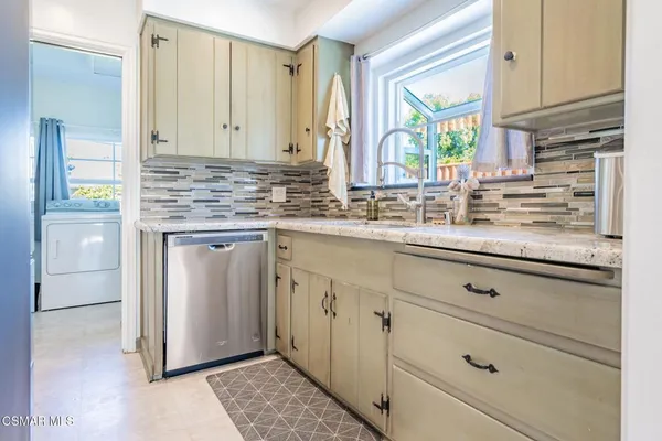 a kitchen with stainless steel appliances a sink stove and cabinets