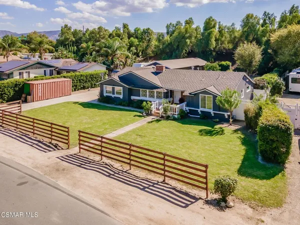 an aerial view of a house with swimming pool and large trees