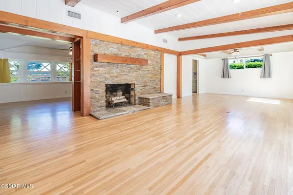 a view of a livingroom with wooden floor and a fireplace