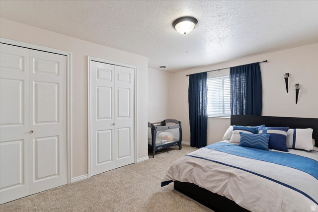 1924 North 2000th Street East Layton, UT 84040 - Photo 30 of 41 Bedroom with two closets, carpet, and a textured ceiling