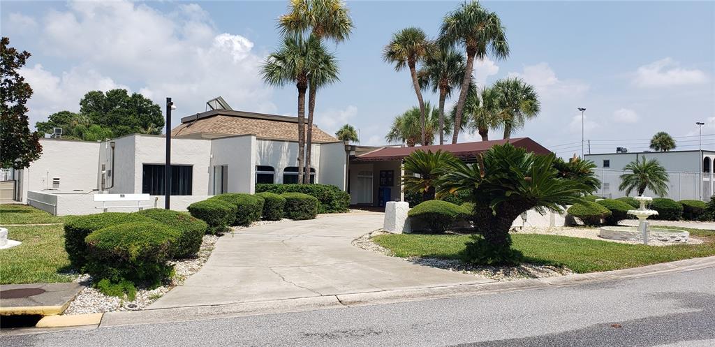 7701 Starkey Road, Unit 102 Seminole, FL 33777 - Photo 22 of 24 a front view of a house with a yard and potted plants